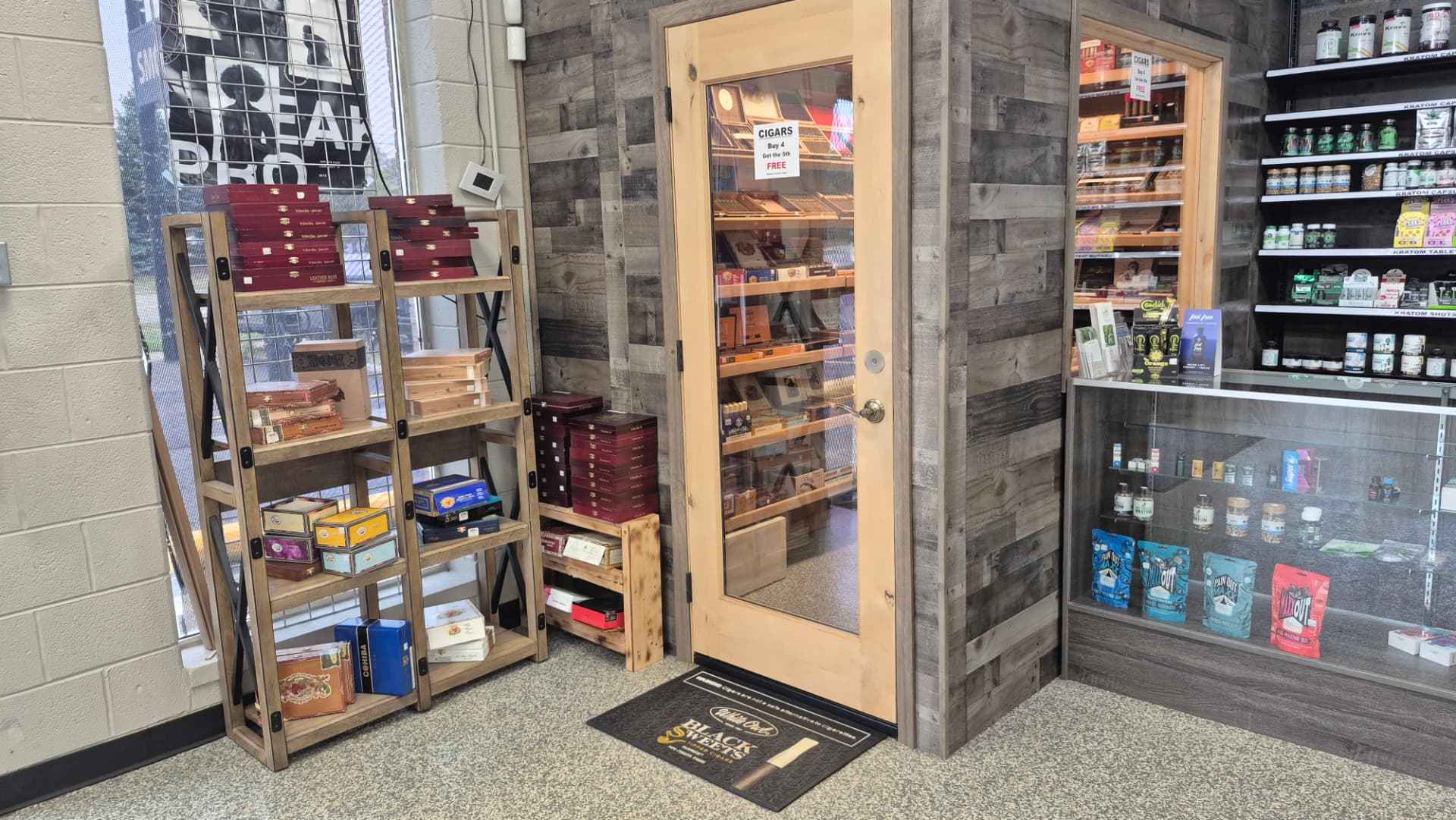 Glass door of the walk-in humidor with cigar box displays at The Hub