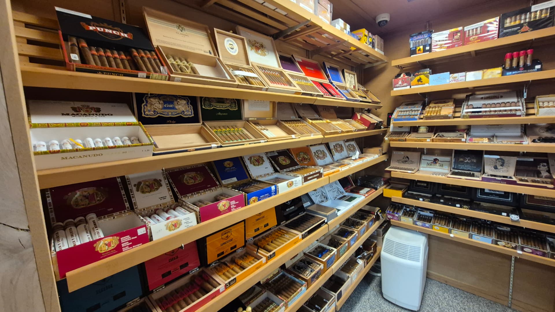 Walk-in humidor shelves stacked with open cigar boxes at The Hub